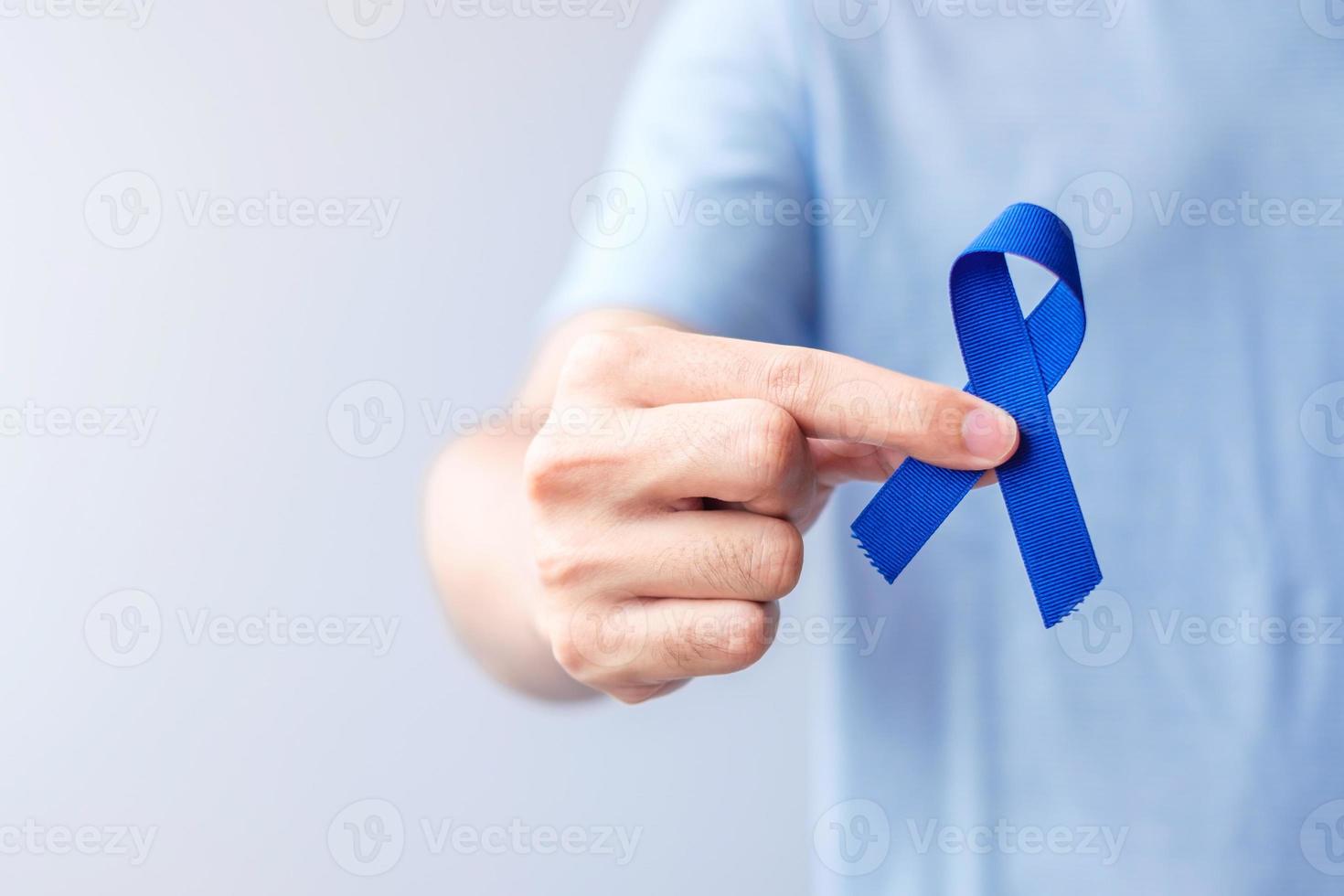 marzo mese di sensibilizzazione sul cancro colorettale, donna che tiene un nastro blu scuro per sostenere le persone che vivono e le malattie. concetto di assistenza sanitaria, speranza e giornata mondiale del cancro foto