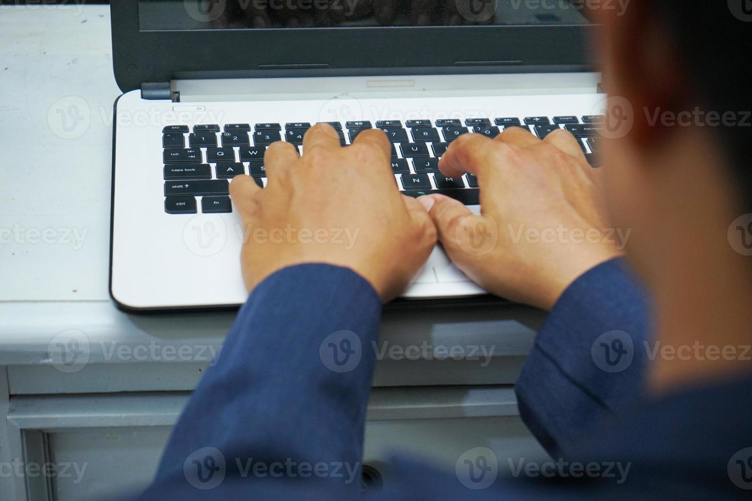 immagine di un asiatico attività commerciale uomo mani Lavorando nel ufficio con il computer portatile computer, digitando su tastiera a il suo scrivania, vicino su foto