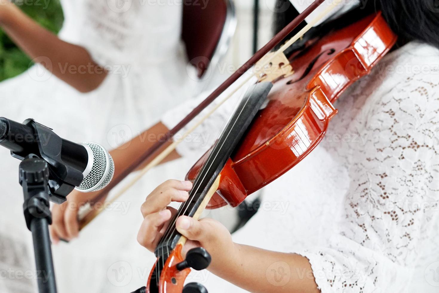 immagine di giovane asiatico ragazza è giocando il violino, vicino su foto