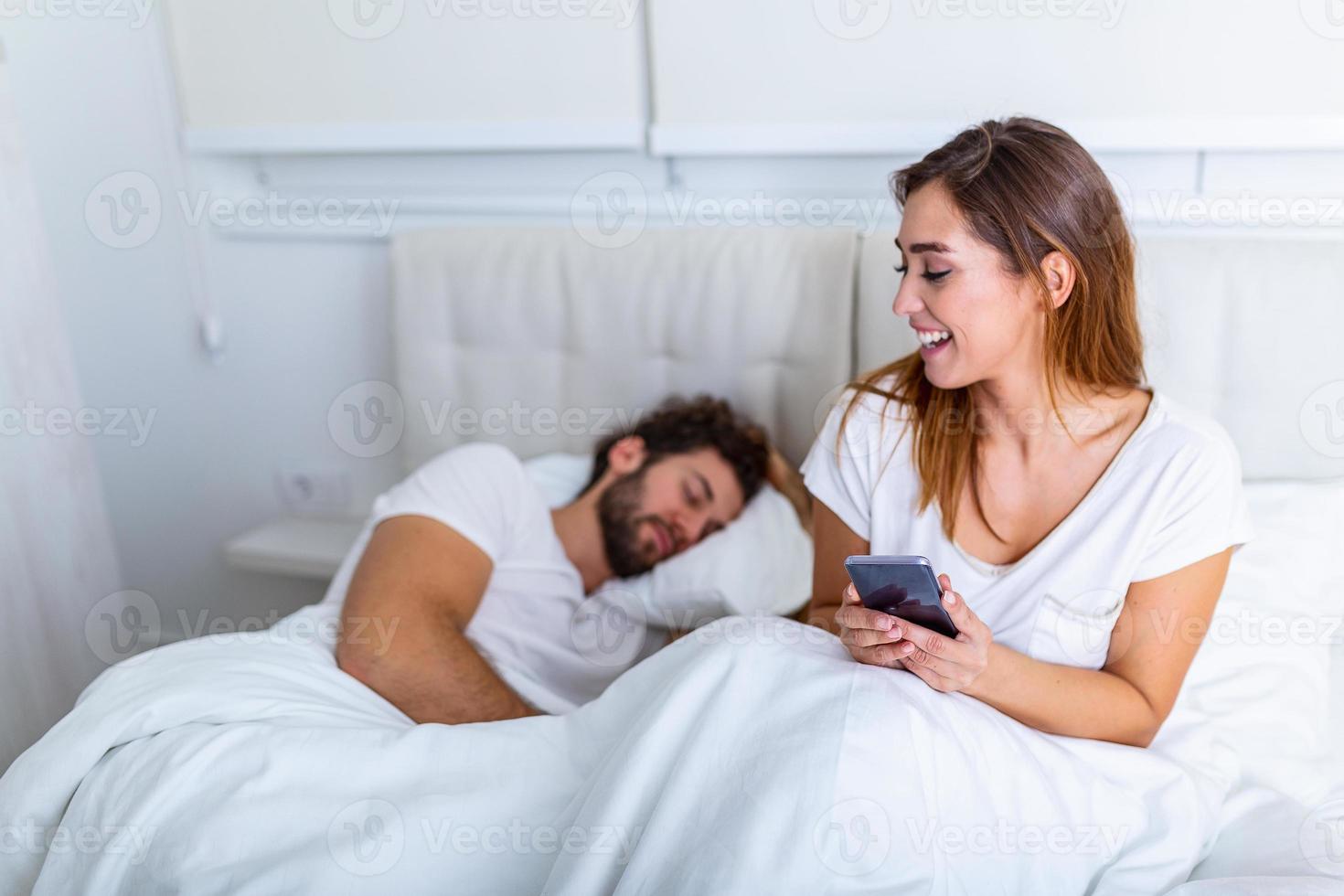 imbrogliare moglie. bellissimo donna chat in privato su cellulare, nascondiglio a partire dal sua addormentato marito, vuoto spazio. imbrogliare fidanzata chat su Telefono mentre fidanzato addormentato nel Camera da letto a notte. foto