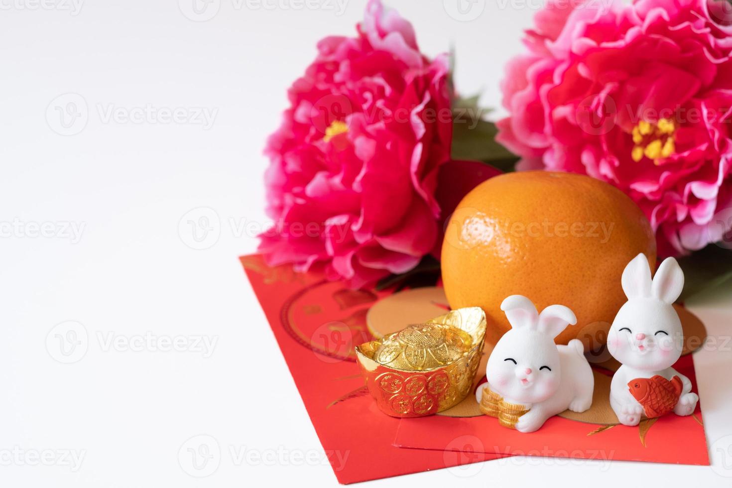 Cinese nuovo anno di il coniglio Festival concetto. arancia, rosso buste, Due conigli e oro lingotto decorato con prugna fiorire su bianca sfondo. foto