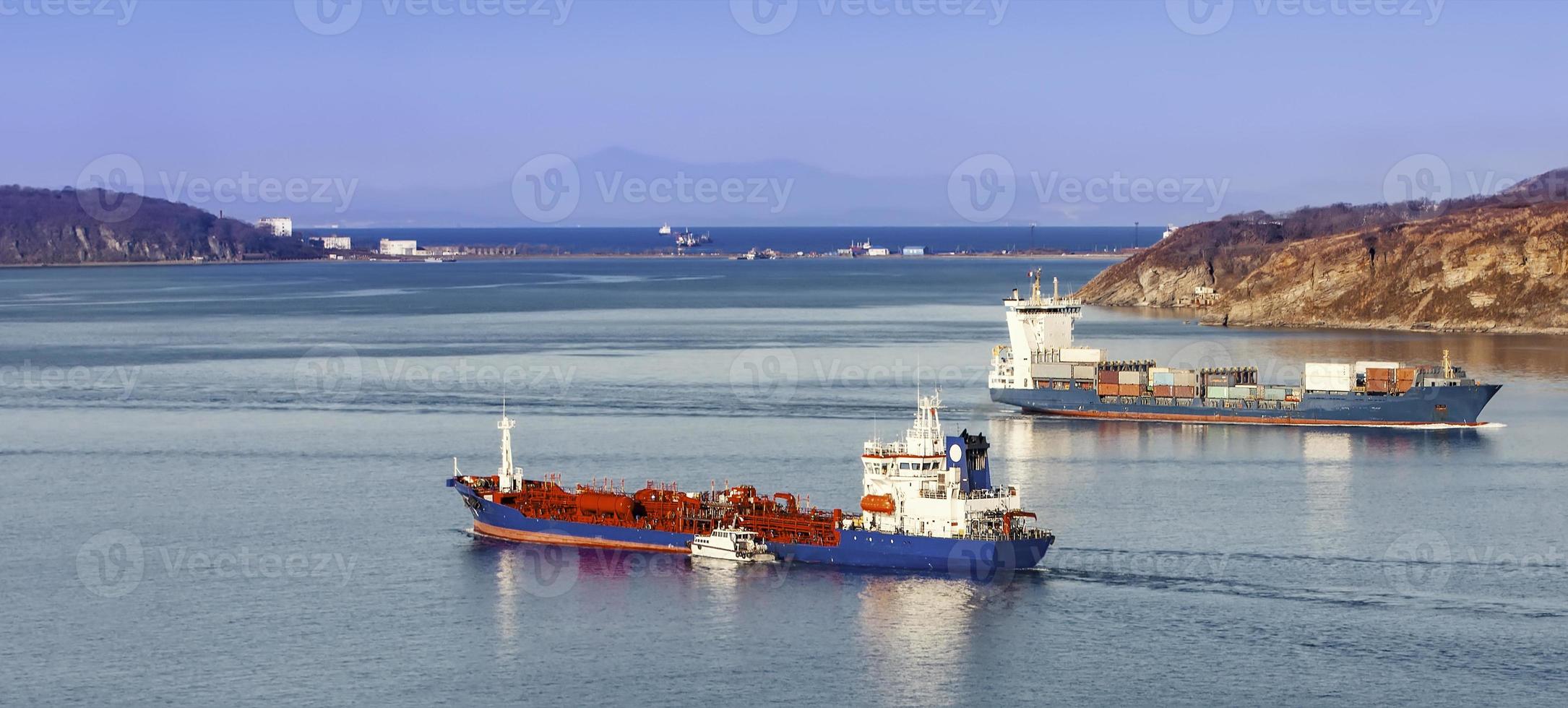 grande nave portacontainer e nave reefer in mare blu foto