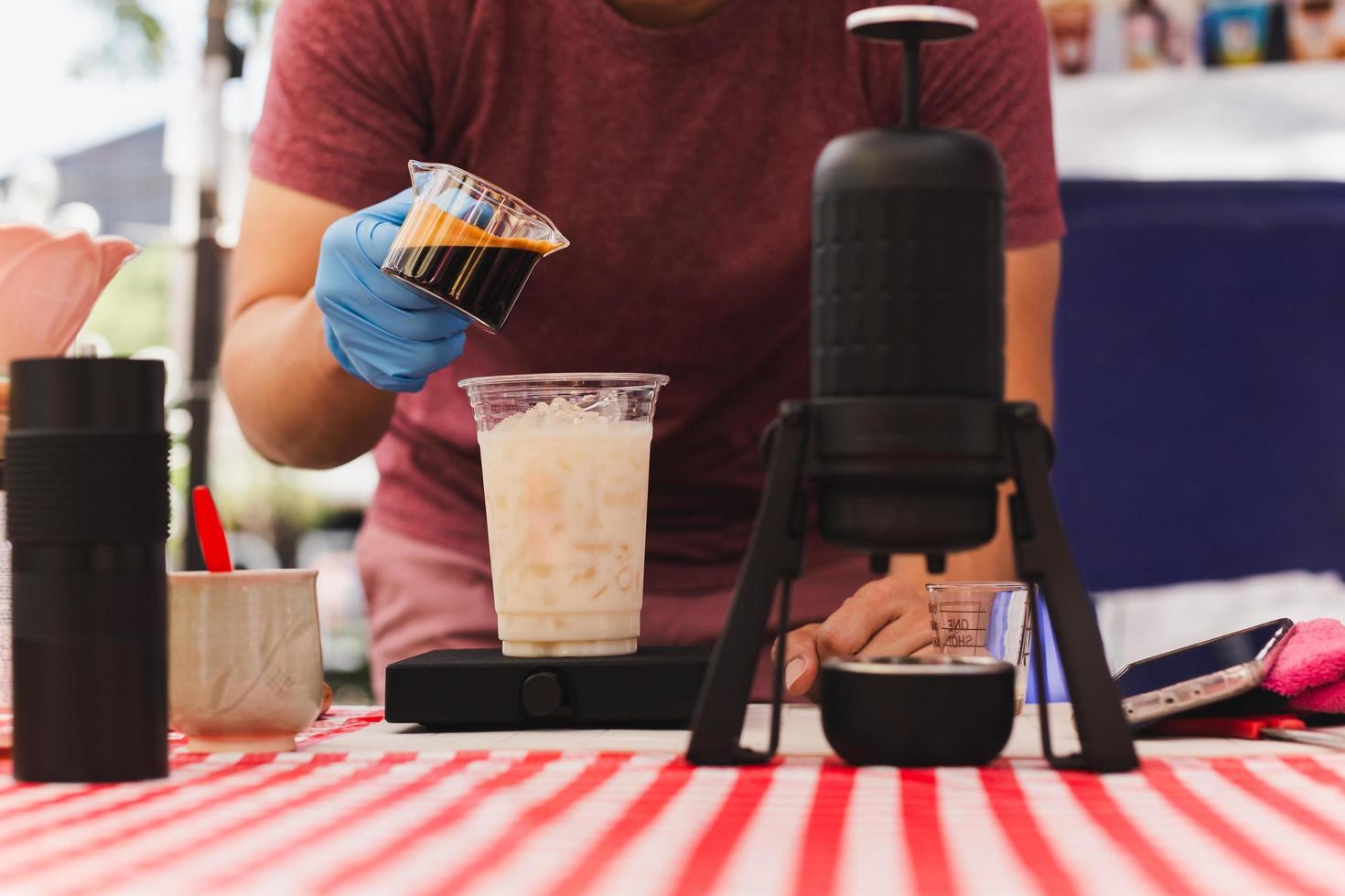 barista scrosciante caffè espresso tiro in un' bicchiere di freddo fresco latte. foto