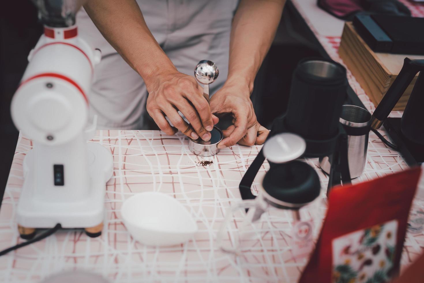 barista urgente terra caffè con manomettere preparazione caffè nel bar. foto