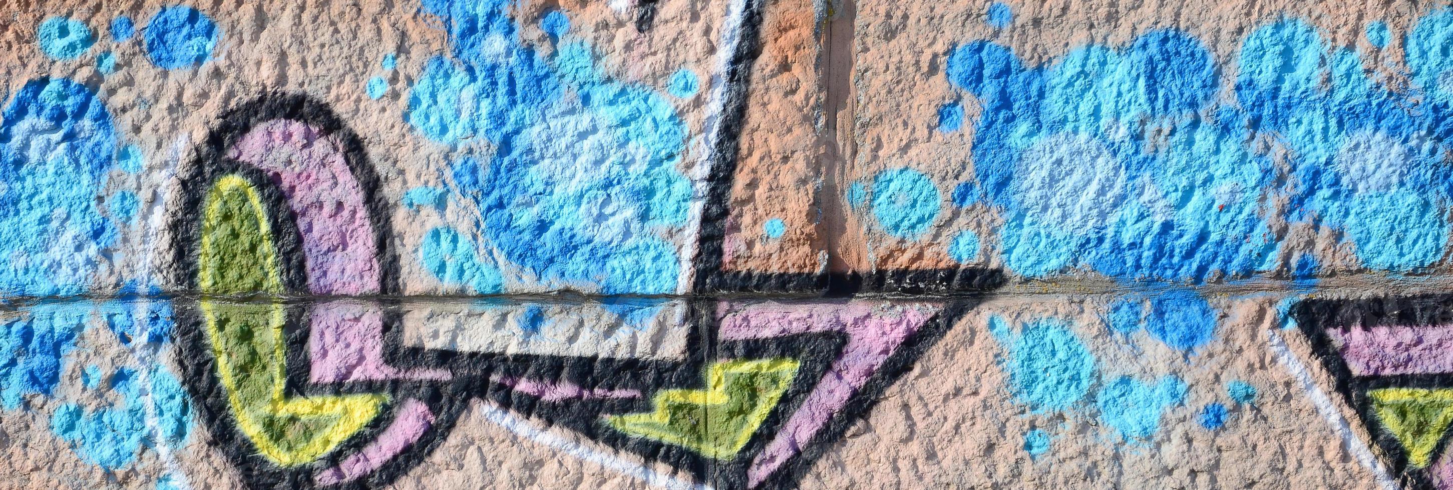 frammento di graffiti disegni. il vecchio parete decorato con dipingere macchie nel il stile di strada arte cultura. colorato sfondo struttura nel caldo toni foto