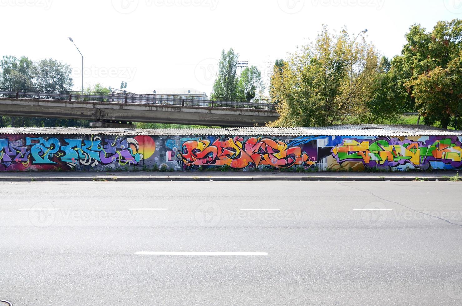 frammento di graffiti disegni. il vecchio parete decorato con dipingere macchie nel il stile di strada arte cultura. multicolore sfondo struttura foto