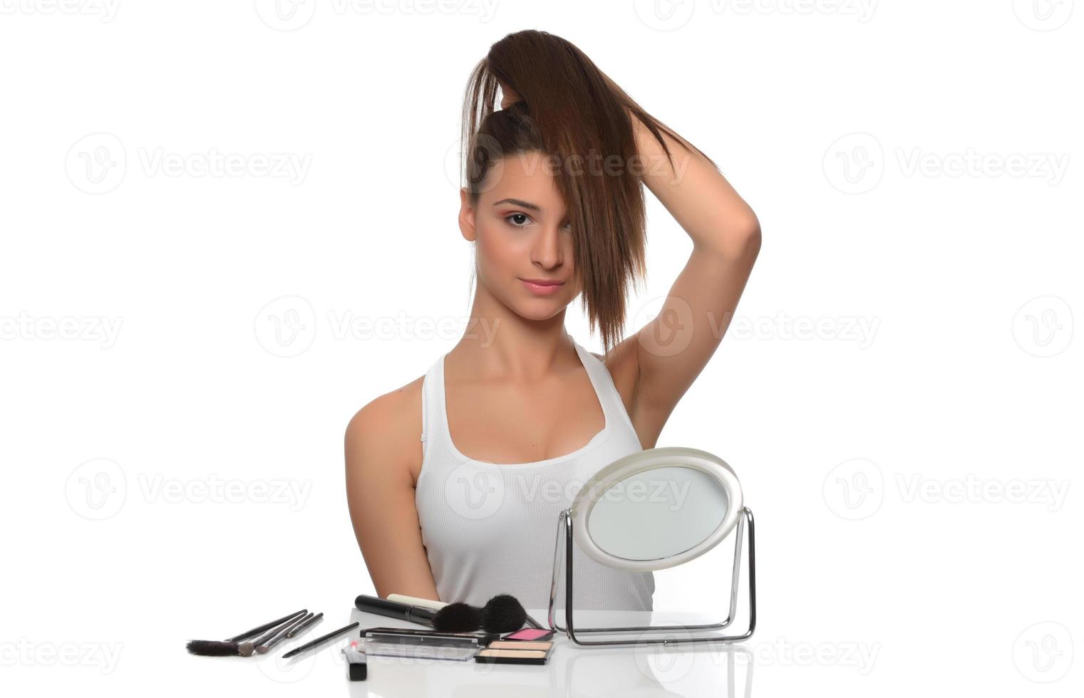 giovane attraente sorridente donna Tenere sua forte capelli foto