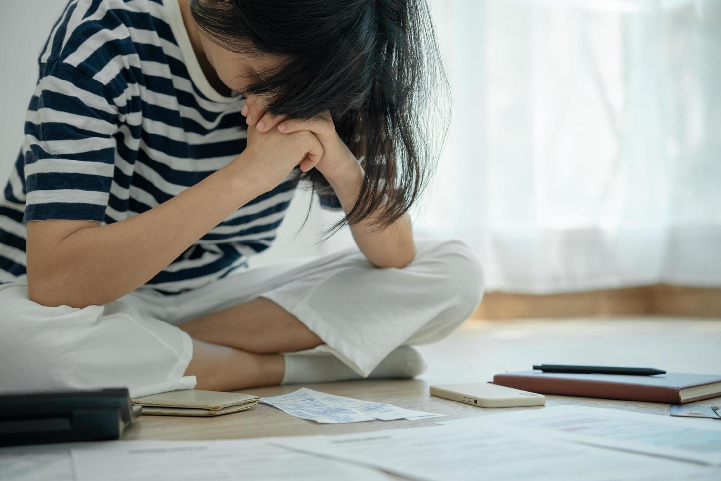 donne siamo stressato e mal di testa di credito carta debito e grande fatture su mano. casalinghe avere guaio pagare mensile acqua, elettricità e telefono fatture. foto