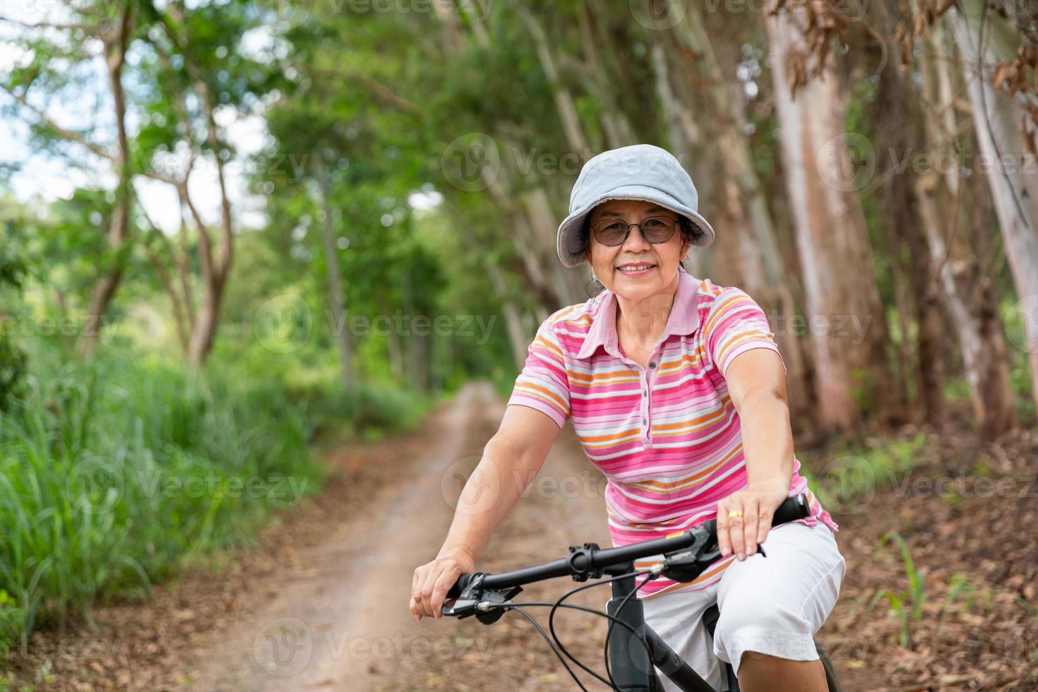 anziano attività commerciale donna, femmina, cavalcata o bicicletta montagna bicicletta nel nazione parco vicino casa cittadina per salutare esercizio nel estate fine settimana foto