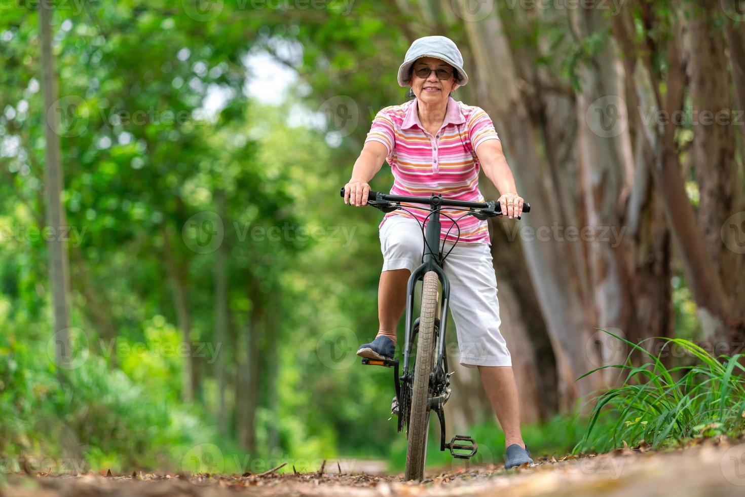 anziano attività commerciale donna, femmina, cavalcata o bicicletta montagna bicicletta nel nazione parco vicino casa cittadina per salutare esercizio nel estate fine settimana foto