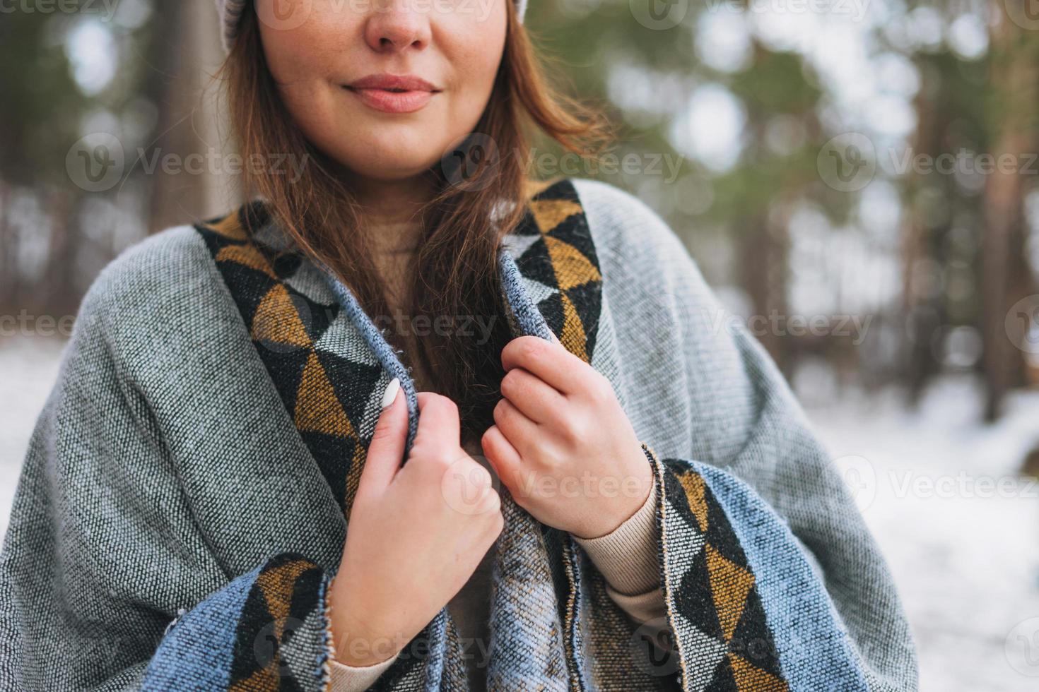 giovane brunetta bellissimo donna nel cappello e grigio poncho nel il inverno foresta foto