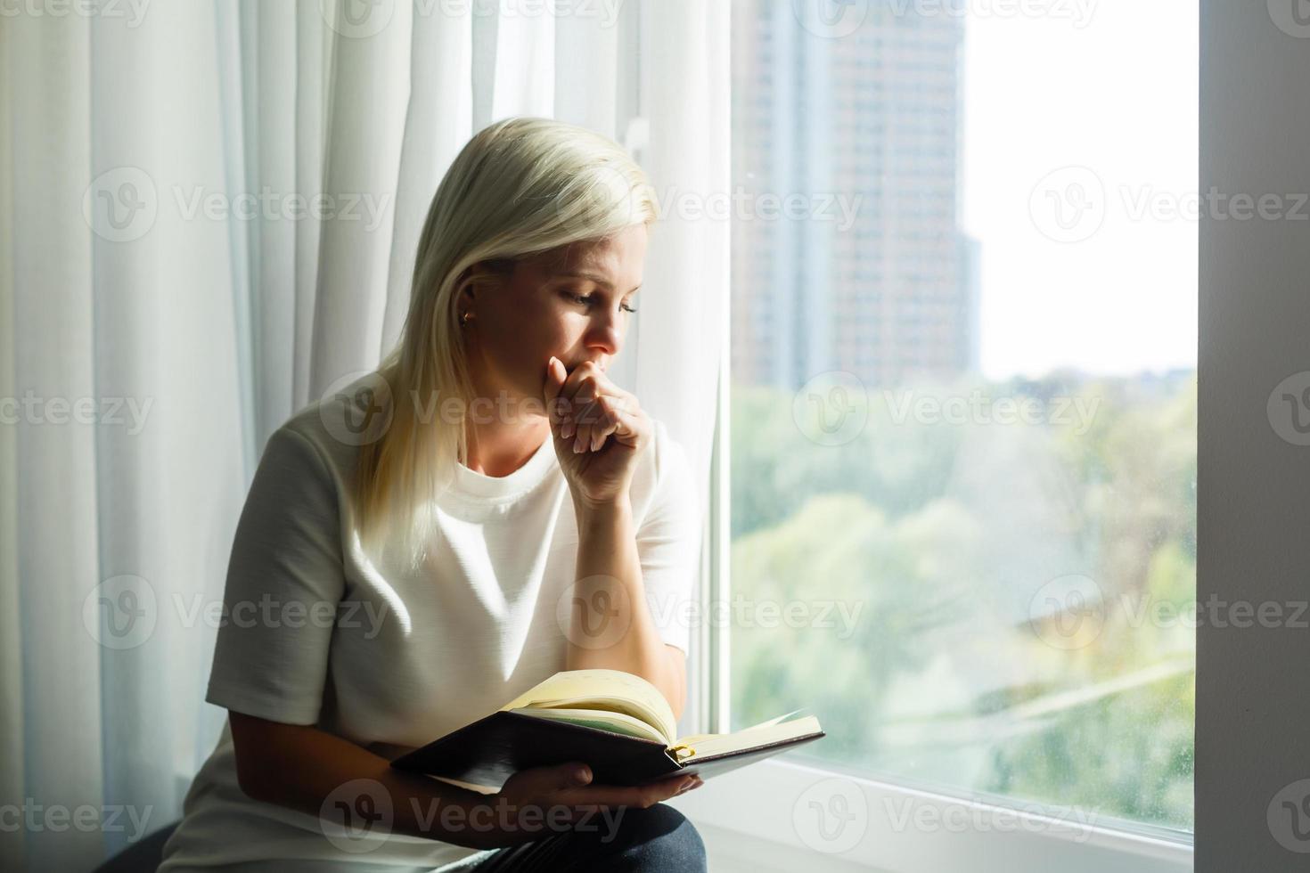 donna preghiere con Bibbia foto