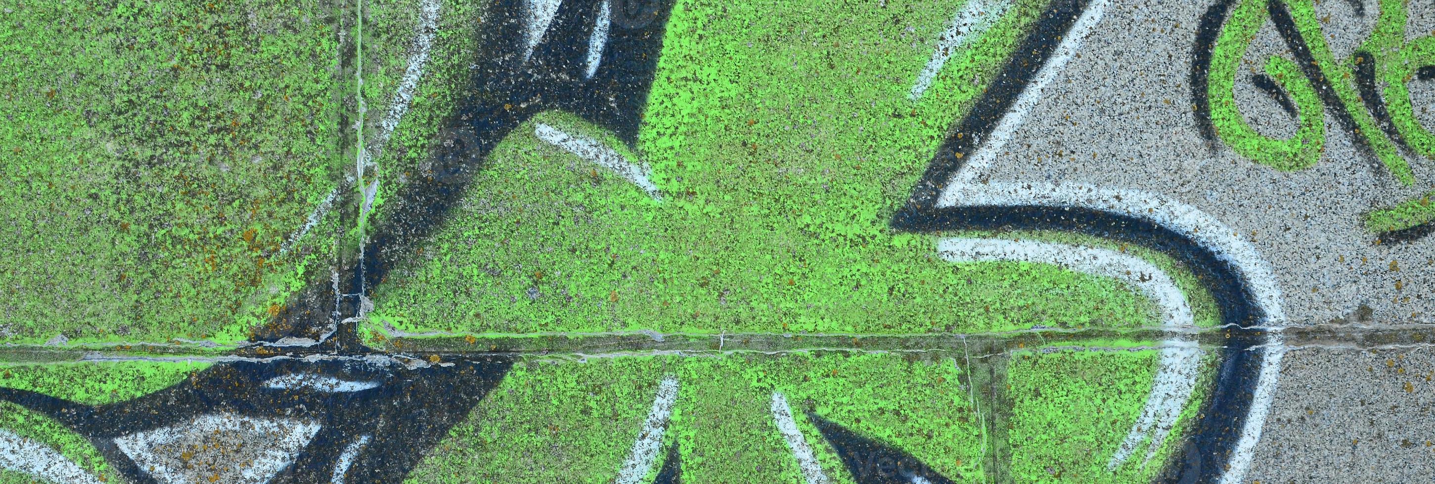 frammento di graffiti disegni. il vecchio parete decorato con dipingere macchie nel il stile di strada arte cultura. colorato sfondo struttura nel verde toni foto