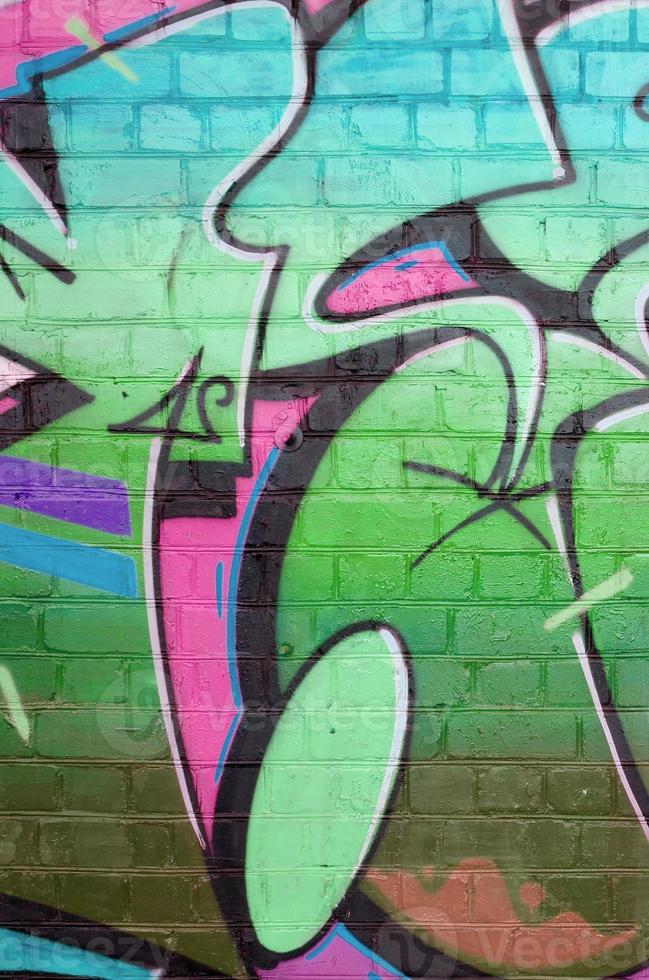 astratto colorato frammento di graffiti dipinti su vecchio mattone parete nel verde colori. strada arte composizione con parti di non scritto lettere e multicolore macchie. subculturale sfondo foto