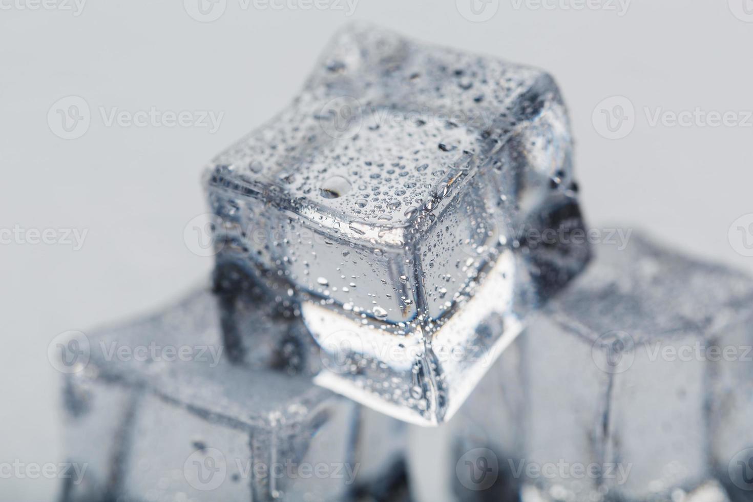 ghiaccio cubo con acqua gocce vicino - su nel macro su un' bianca sfondo. rinfrescante Ghiaccio. isolato foto