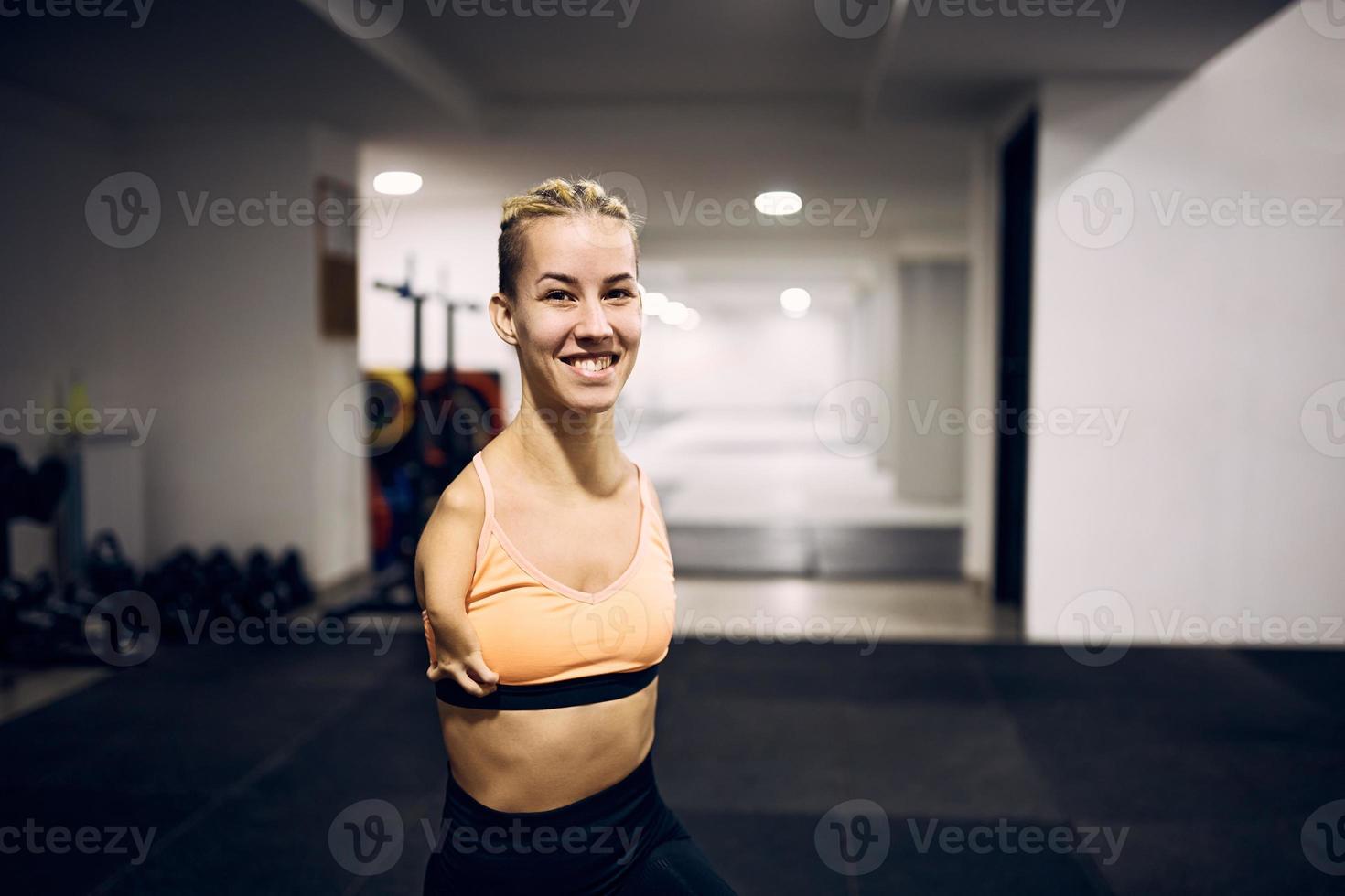 contento senza braccia atletico donna avendo gli sport formazione nel un' Palestra e guardare a telecamera. foto