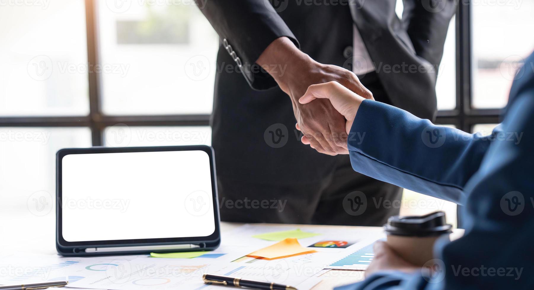 primo piano di uomini d'affari che si stringono la mano, finendo la riunione, etichetta aziendale, congratulazioni, concetto di fusione e acquisizione foto