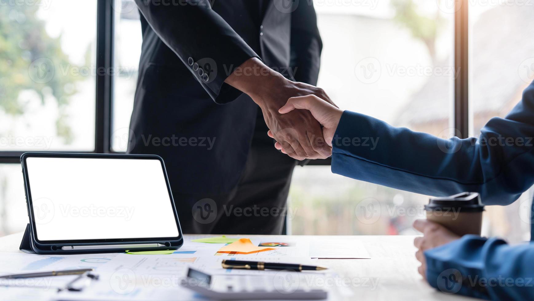 primo piano di uomini d'affari che si stringono la mano, finendo la riunione, etichetta aziendale, congratulazioni, concetto di fusione e acquisizione foto