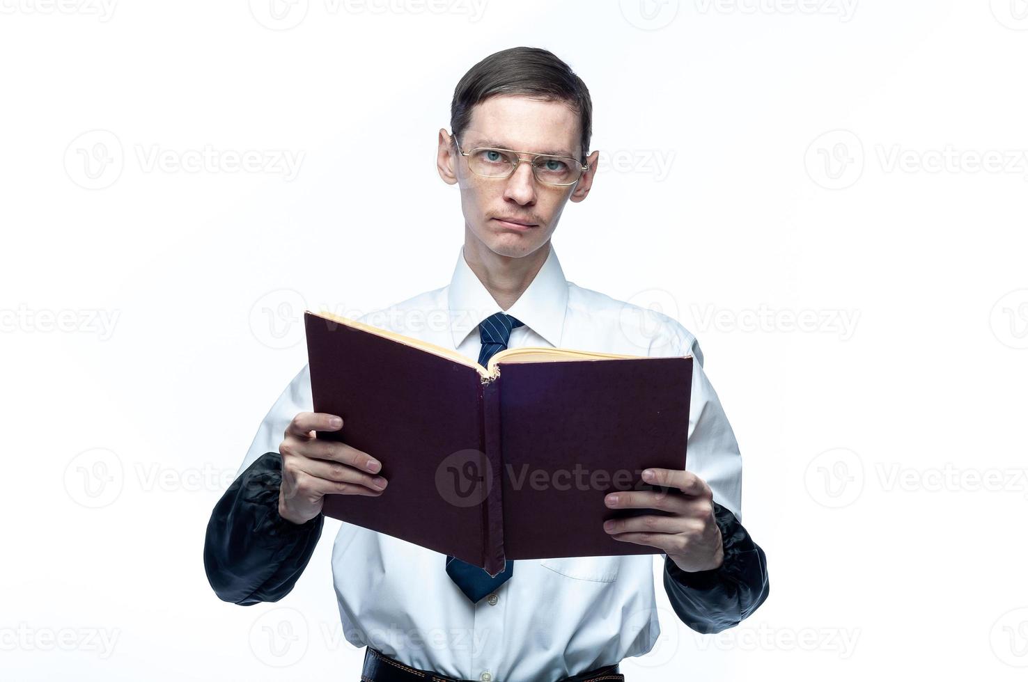 un uomo d'affari in cravatta e occhiali con una rivista in mano su uno sfondo bianco e isolato foto
