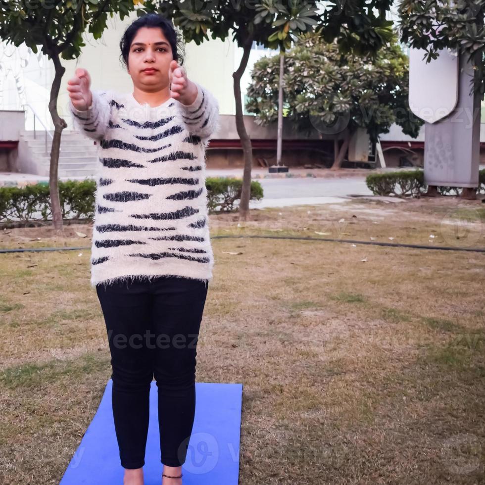 giovane indiano donna praticante yoga all'aperto nel un' parco. bellissimo ragazza pratica di base yoga posa. quiete e relax, femmina felicità. di base yoga esercizio all'aperto foto