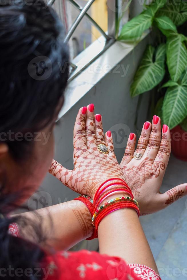 bellissimo donna vestito su come indiano tradizione con alcanna mehndi design su sua tutti e due mani per celebrare grande Festival di karwa chaut, karwa chauth celebrazioni di indiano donna per sua marito foto