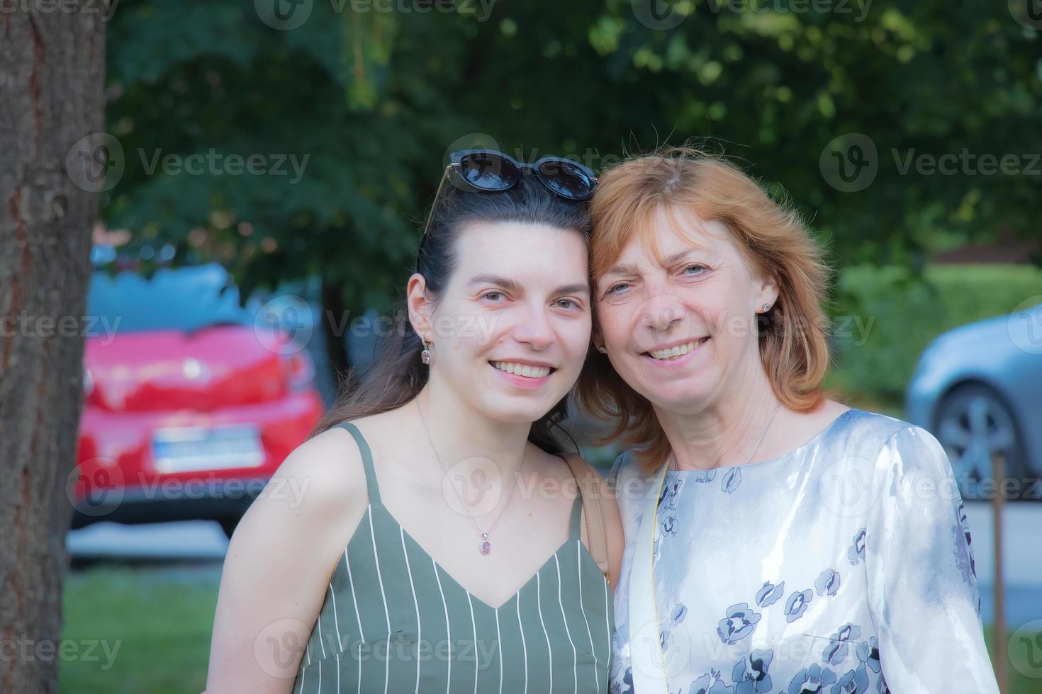 bellissimo anziano madre e sua adulto figlia Guarda a il telecamera e Sorridi foto