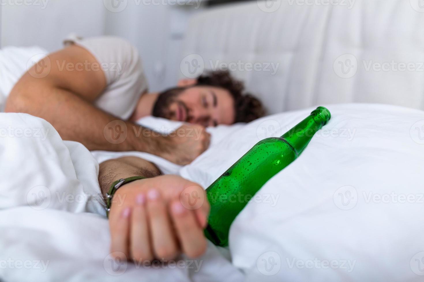 dopo potabile. ubriaco barbuto adulto uomo dire bugie su il letto e addormentato dopo potabile molte di alcol, vuoto bottiglia su il letto, alcolismo, alcool dipendenza e persone concetto foto