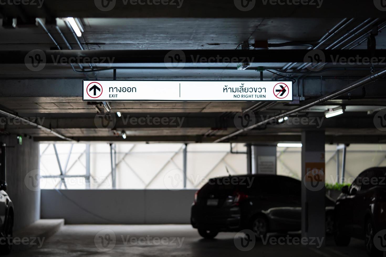 parcheggio auto illuminazione scatola è sospeso su soffitto. tailandese laungae lettera su illuminazione scatola a il sinistra lato significare Uscita e giusto lato significare no giusto girare foto