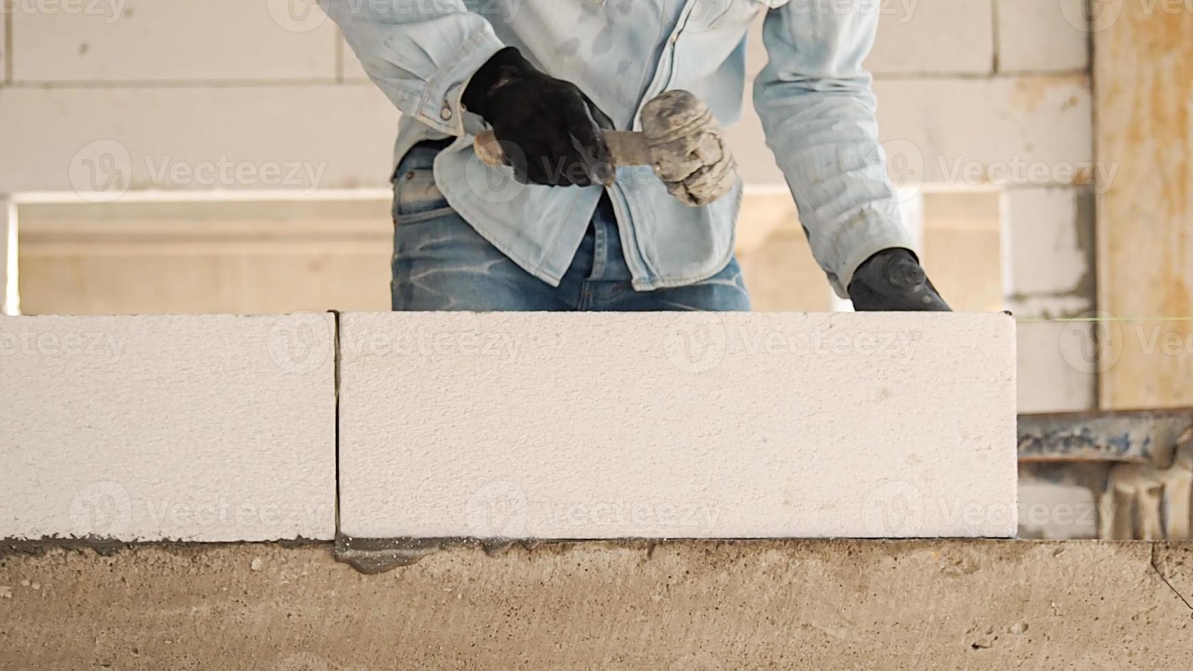 costruzione lavoratori siamo fabbricazione bianca leggero calcestruzzo blocchi quello siamo meglio di cemento mattoni, popolare nel il costruzione di le case e pubblico edifici. foto