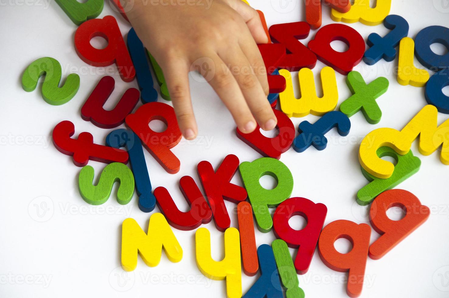 mano Tenere di legno colore lettere su bianca sfondo. scuola e educativo concetto. foto