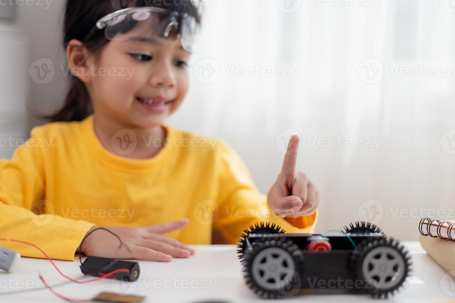 gli studenti asiatici imparano a casa a codificare auto robot e cavi di schede elettroniche in stelo, vapore, matematica ingegneria scienza tecnologia codice informatico in robotica per bambini concetto. foto