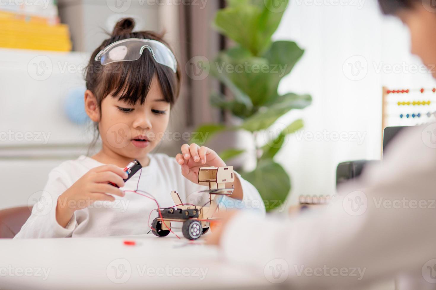 gli studenti asiatici imparano a casa a codificare auto robot e cavi di schede elettroniche in stelo, vapore, matematica ingegneria scienza tecnologia codice informatico in robotica per bambini concetto. foto