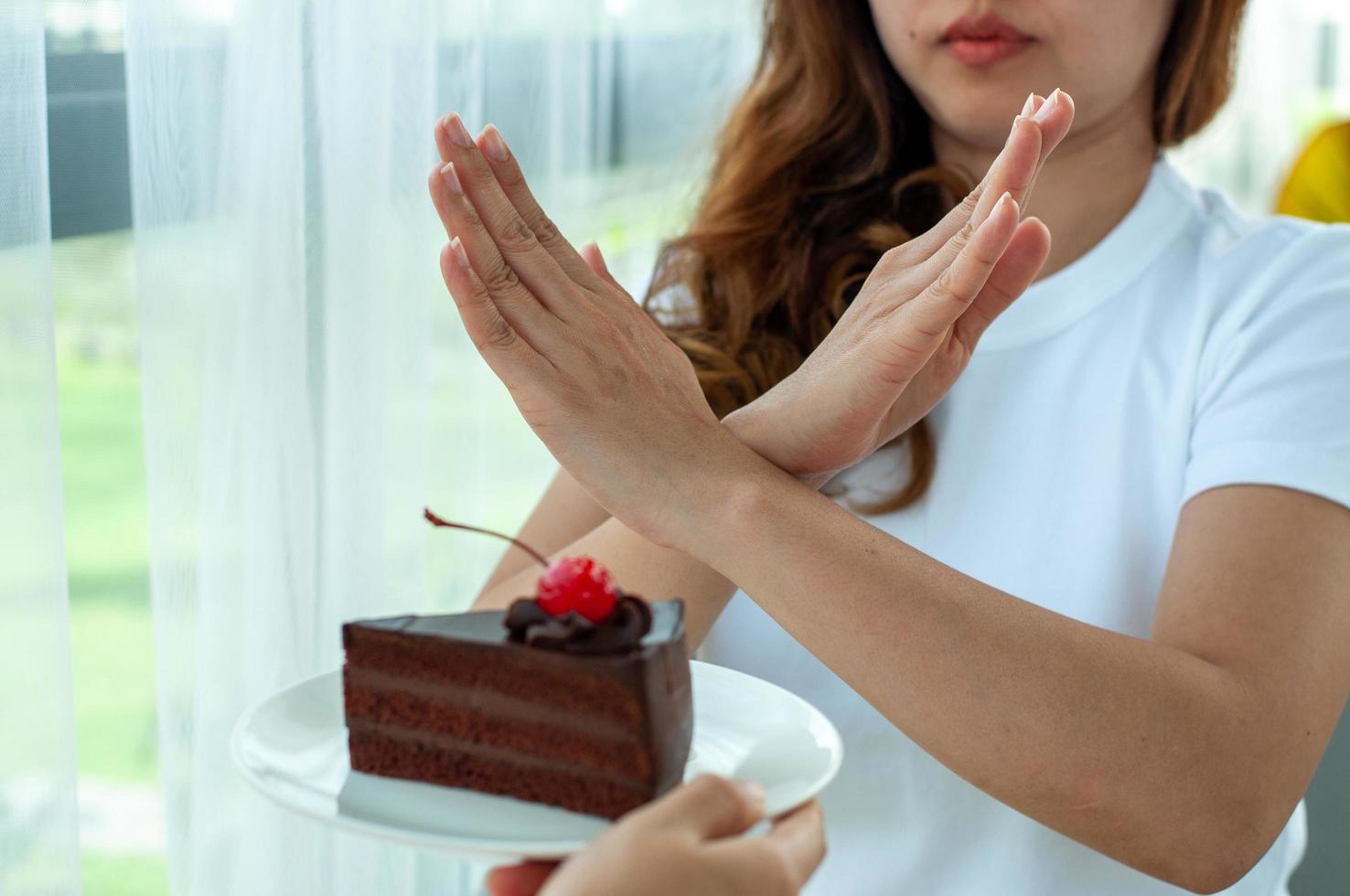 il donne Usato per spingere il torta piatto con il le persone. fare non mangiare dolci per peso perdita. foto