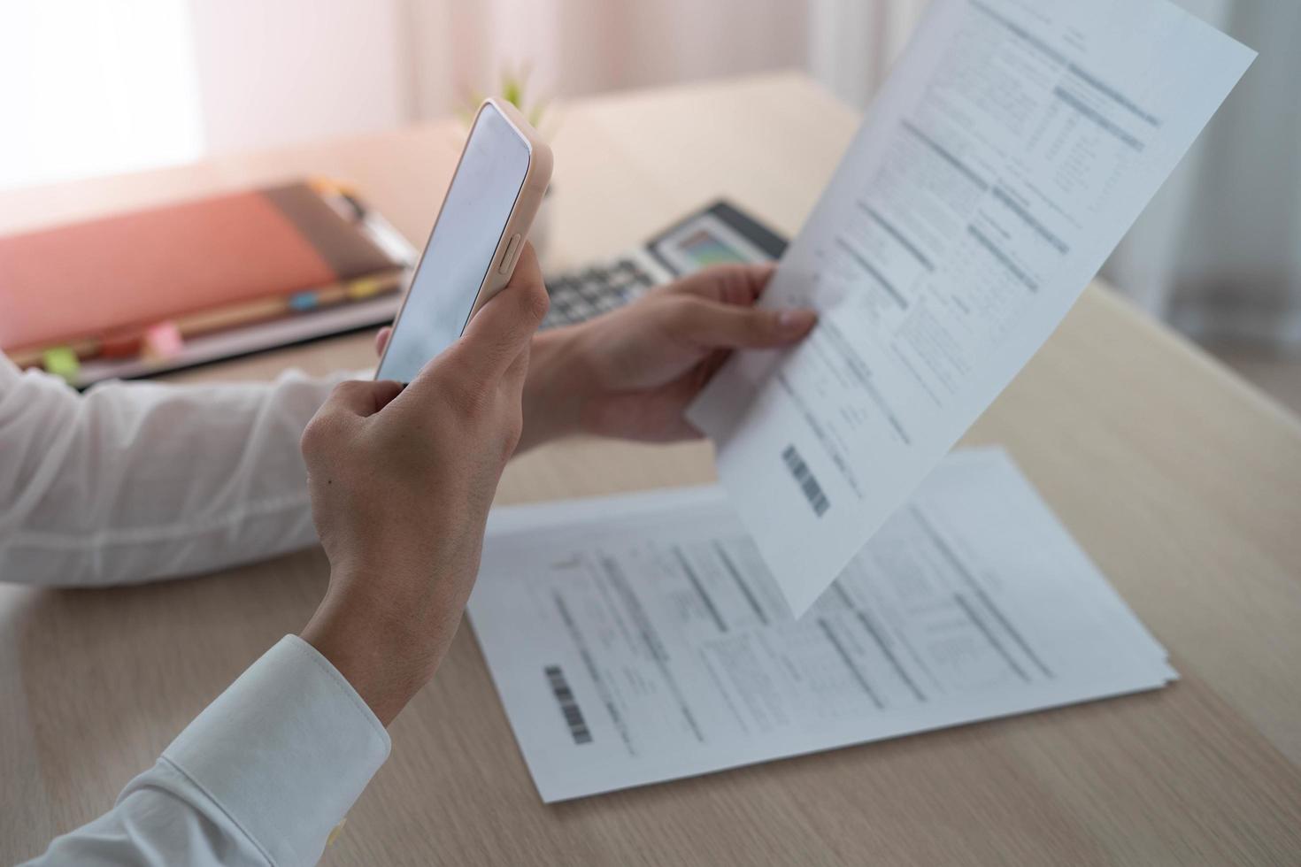 un' attività commerciale uomo usi il suo Telefono per scansione un' codice a barre per pagare il suo mensile credito carta conto dopo ricevente un fattura. in linea conto pagamento concetto foto