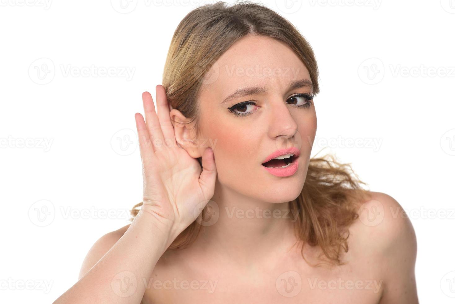 avvicinamento di donna detiene sua mano vicino orecchio e ascolta accuratamente foto