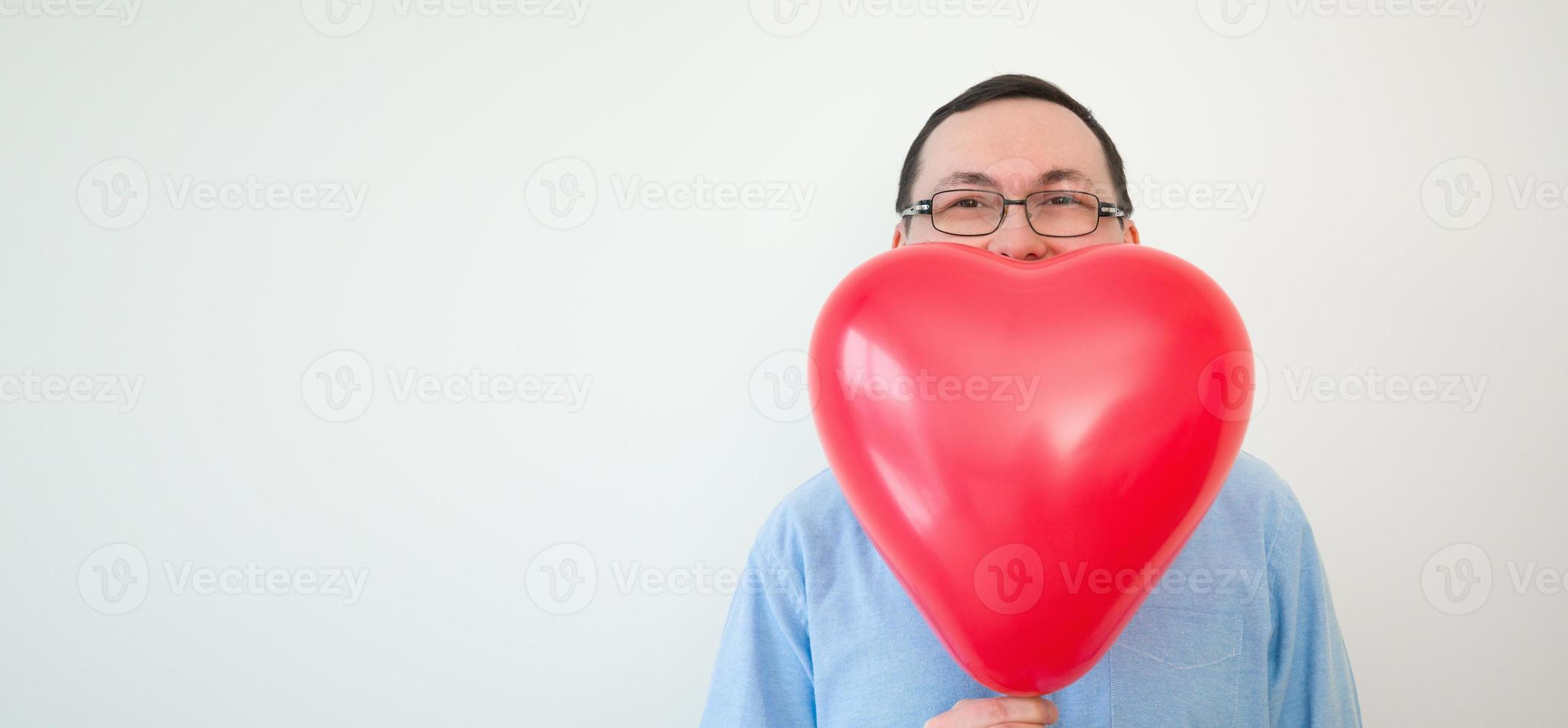 san valentino giorno bandiera con posto per testo. uomo nascondiglio dietro a cuore Palloncino foto