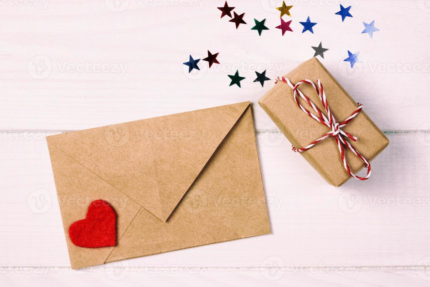 Busta posta con rosso cuore e regalo scatola al di sopra di bianca tonica, Vintage ▾ di legno sfondo. San Valentino giorno carta, amore o nozze saluto concetto foto