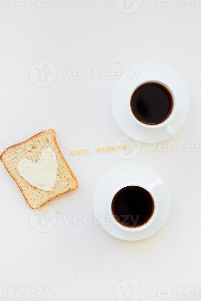 Sandwich per prima colazione nel modulo di cuore con formaggio - bene mattina cartello e Due caffè tazze foto