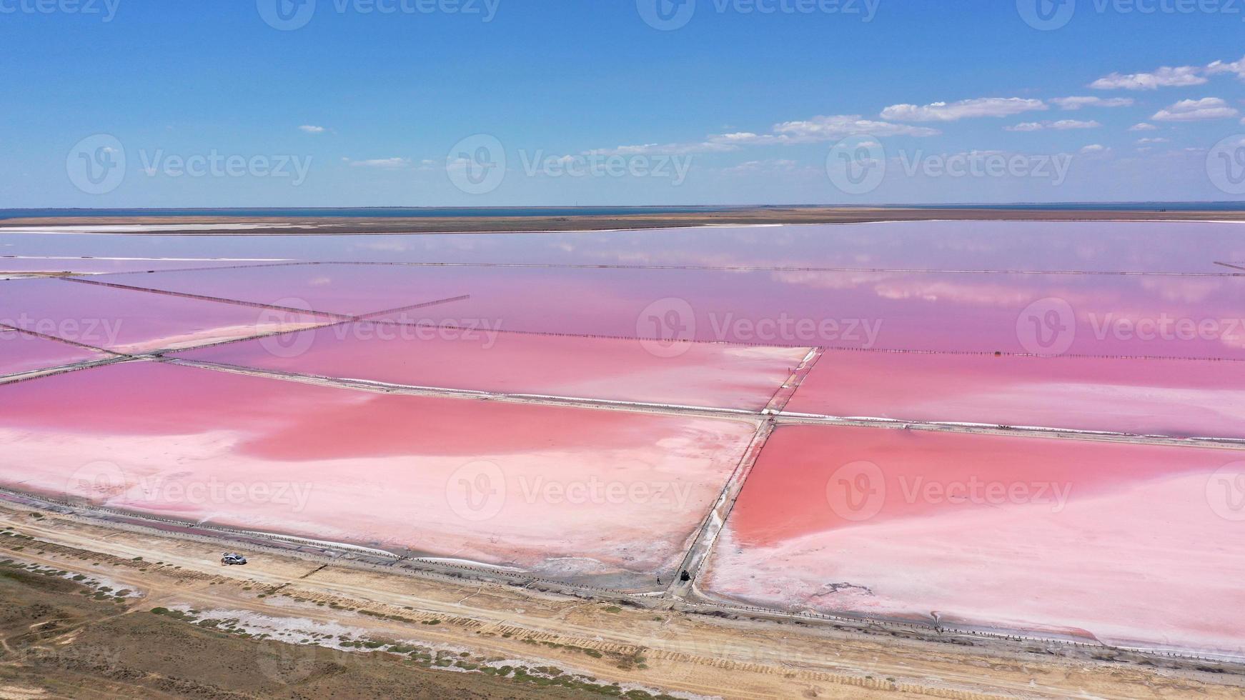 veduta aerea del sale bianco sulle rive dell'isola nell'isola rosa e nel cielo blu. lago lemuria, ucraina. il lago diventa naturalmente rosa a causa dei sali e dell'artemia dei piccoli crostacei nell'acqua foto