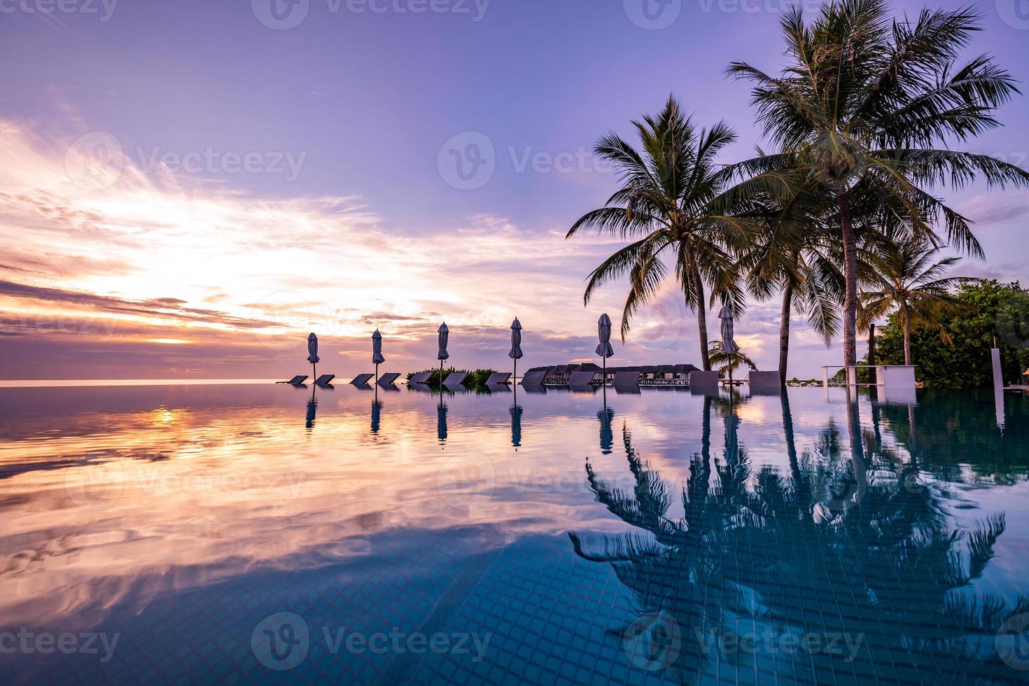 lusso nuoto piscina su il spiaggia, tranquillo scena di esotico tropicale paesaggio con copia spazio, estate sfondo per vacanza vacanze. bellissimo bordo piscina e tramonto cielo. lussuoso tropicale spiaggia foto