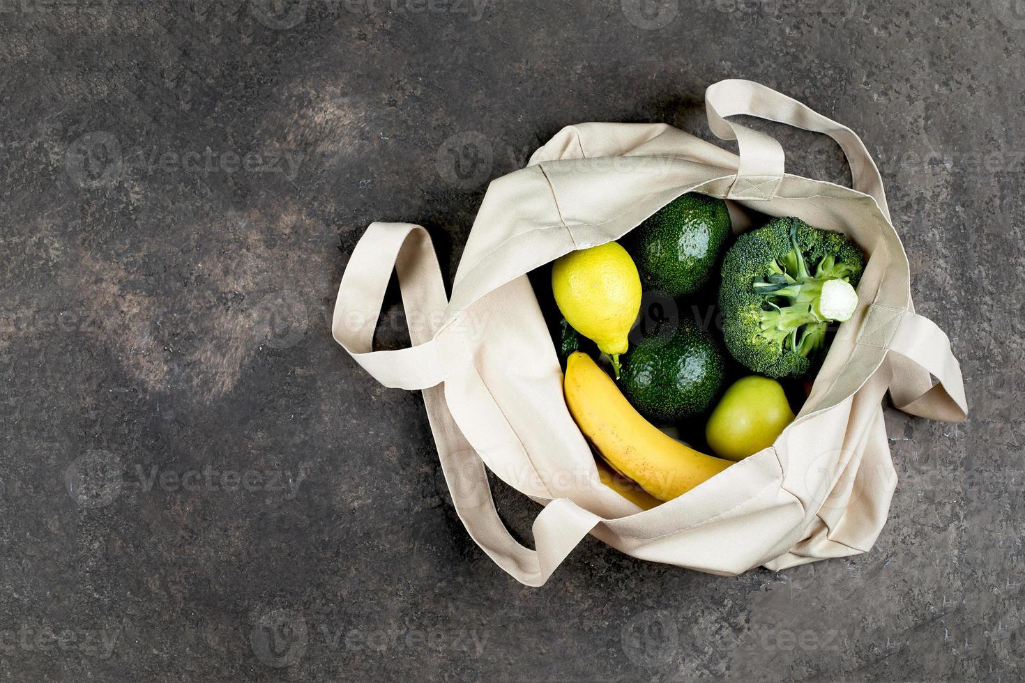 cotone shopping Borsa con verde verdure e giallo frutta. superiore Visualizza, piatto posizione, copia spazio. zero sciupare, eco amichevole concetto. foto