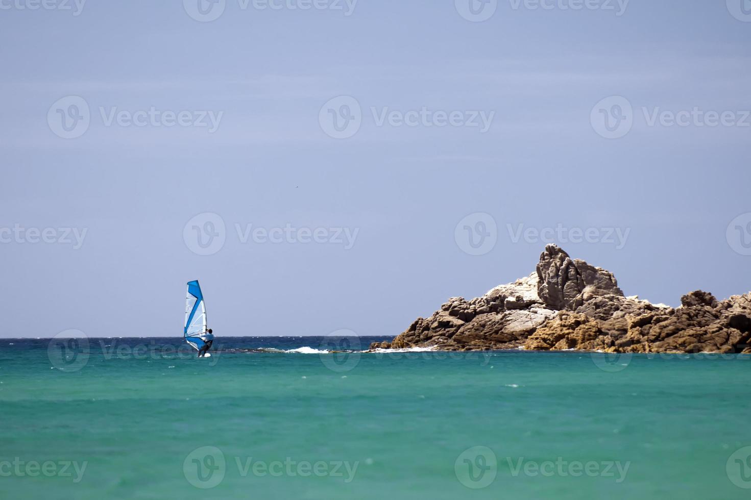 un' windsurf nel il turchese blu mare nel sardegna Italia foto