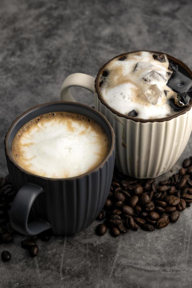 caldo latte macchiato e ghiacciato latte macchiato con caffè fagioli su calcestruzzo sfondo. foto