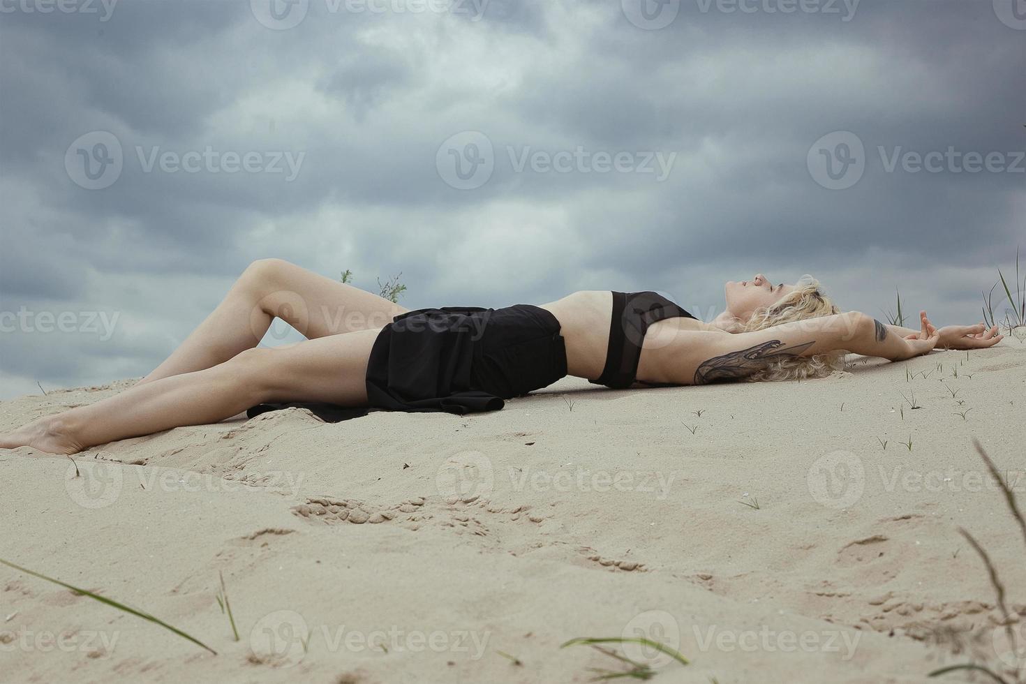 sensuale spoglio signora dire bugie su spiaggia panoramico fotografia foto