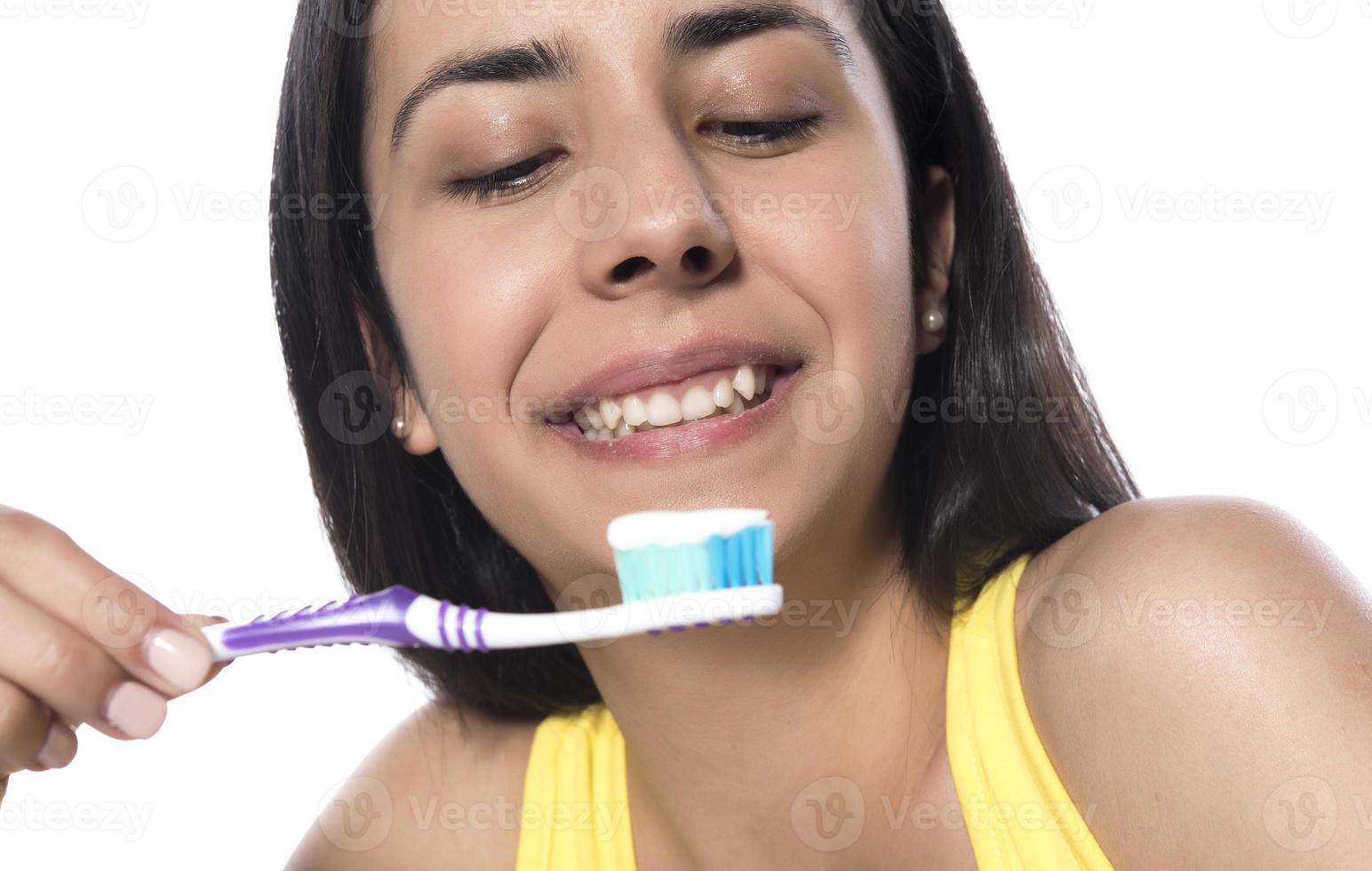 contento giovane donna con salutare denti Tenere un' dente spazzola foto