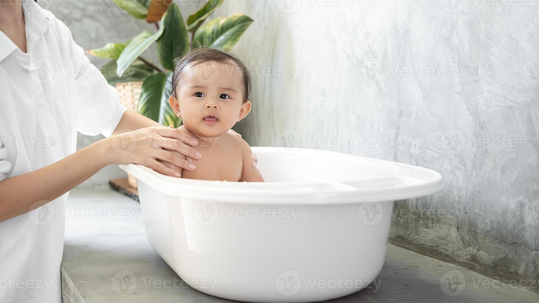 adorabile bambino ragazza assunzione un' bagno con madre, famiglia, bambino, infanzia e paternità concetto foto