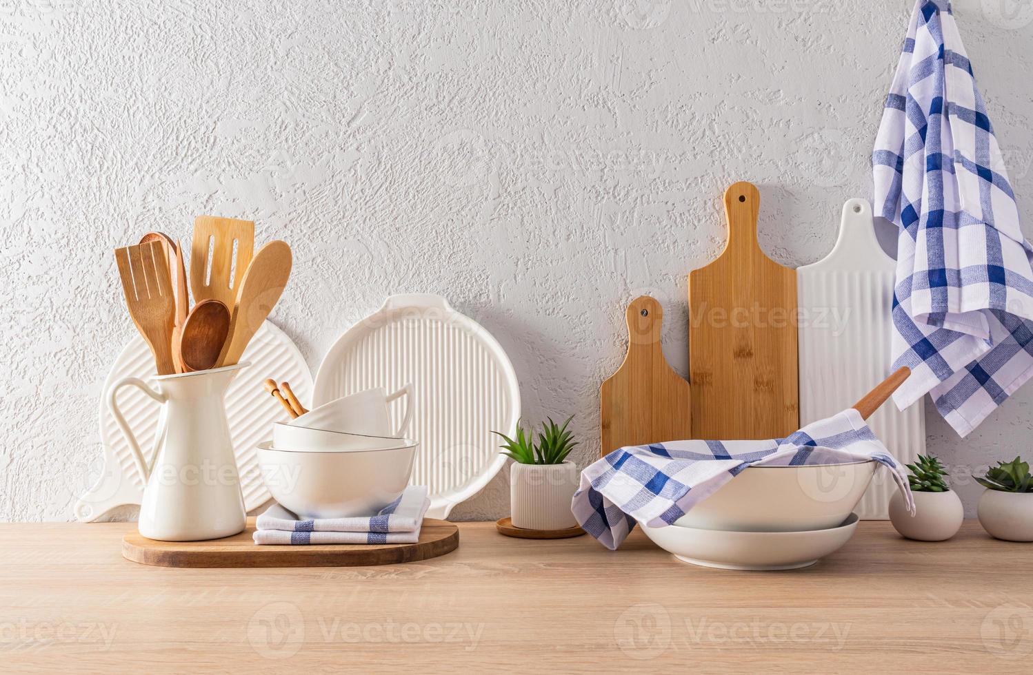 cucina utensili e utensili su un' di legno controsoffitto di fronte il grigio cemento parete. interno di un' moderno cucina spazio nel leggero colori. foto