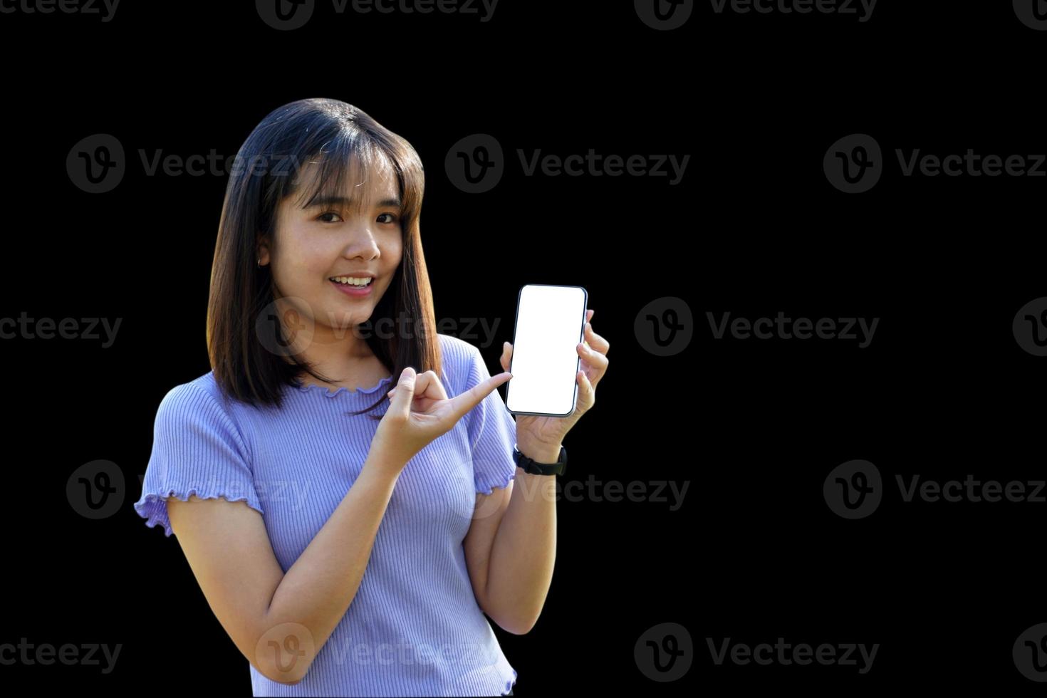 sorridente asiatico donna giocando e aggiornare nuovo applicazioni. sua mano appuntito a il Telefono con vuoto schermo spazio di lavoro la zona chat su nero sfondo. morbido e selettivo messa a fuoco. foto