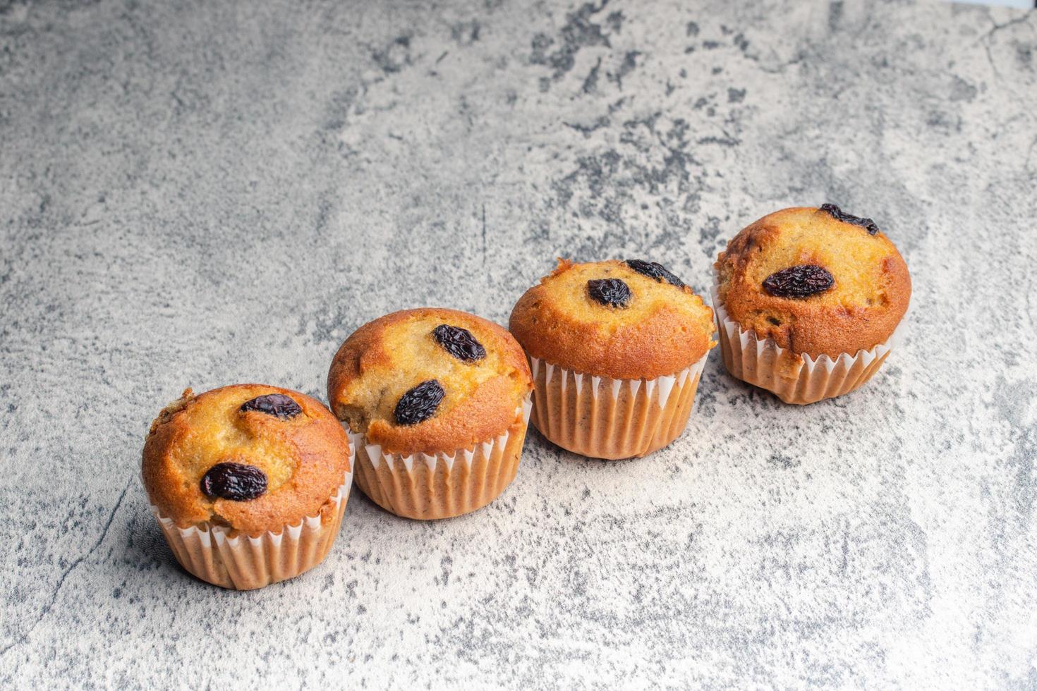 Banana cupcakes cosparso con uva passa. copia spazio su grigio sfondo. foto