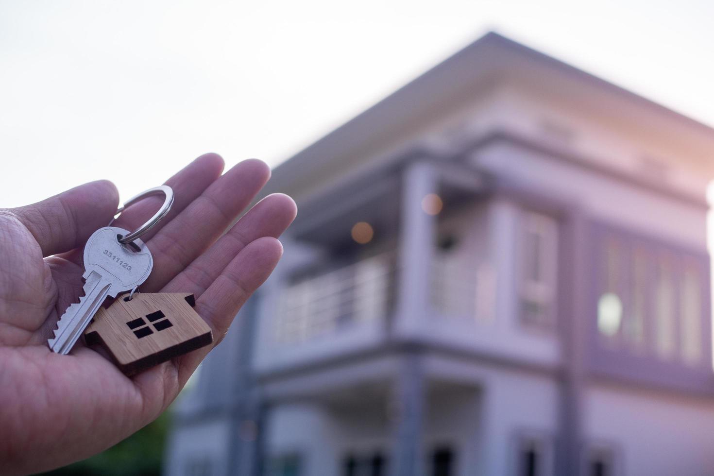 proprietario sblocca il Casa chiave per nuovo casa. vero tenuta agenti, i saldi agenti casa per vendita e per affitto foto